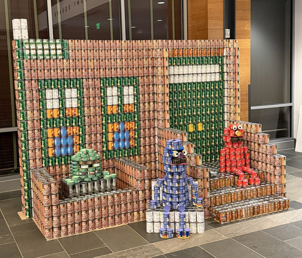 Nitsch's sculpture: Oscar the Grouch, Grover, and Elmo sit on the iconic Sesame Street stoop, all built out of cans