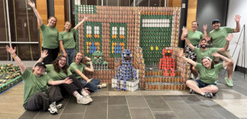 Nitsch build group posing with Sesame Street Canstruction sculpture