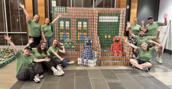 Nitsch build group posing with Sesame Street Canstruction sculpture