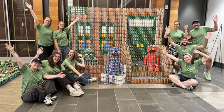 Nitsch build group posing with Sesame Street Canstruction sculpture